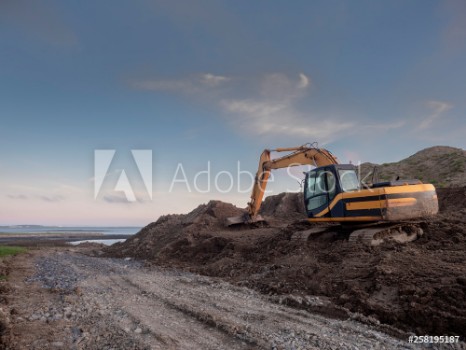 Picture of Digger working on a construction site clean blue sky Orange color of the digger
